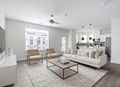 Thumbnail 17 of 17 - A modern living room with a white couch, wooden chairs, and a coffee table.