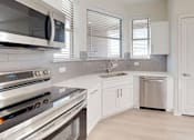 Thumbnail 10 of 17 - A modern kitchen with stainless steel appliances and white cabinetry.
