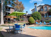 Thumbnail 3 of 30 - our apartments have a pool and patio with chairs and umbrella at Infinity on the Mark, Dallas, TX, 75243