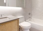 Thumbnail 7 of 17 - A white toilet sits next to a sink in a bathroom. at The Ellington Apartments, Apartments, New York, NY