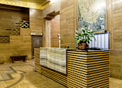 Thumbnail 14 of 24 - A reception desk with a plant on top and a painting on the wall.