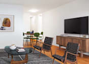Thumbnail 2 of 12 - A living room with a white couch, a coffee table, and a television.at Carnegie Mews, New York, NY