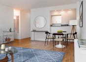 Thumbnail 3 of 12 - A modern living room with a grey sofa, a coffee table, and a dining table set up.at Carnegie Mews, New York, NY 10019