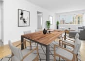 Thumbnail 7 of 12 - A modern dining room with a wooden table and grey chairs at The Caldwell Apartments, New York, 10028