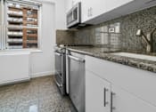 Thumbnail 12 of 12 - A kitchen with a dishwasher and a microwave at The Caldwell Apartments, New York, NY