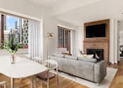 Thumbnail 14 of 17 - A living room with a fireplace and a flat screen TV at The Ellington Apartments, New York
