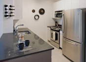 Thumbnail 8 of 15 - A kitchen with a stainless steel refrigerator and oven at The Maximilian Apartments, New York, 11101