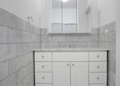 Thumbnail 12 of 18 - A bathroom with a white vanity and a mirror.at Sutton Collection, New York