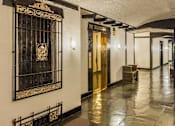 Thumbnail 13 of 18 - A hallway with a black and gold door and a red counter. at Sutton Collection Apartments, New York, NY, 10022