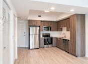 Thumbnail 13 of 22 - A modern kitchen with wooden cabinets and stainless steel appliances.