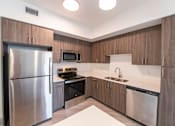 Thumbnail 3 of 22 - A modern kitchen with a stainless steel refrigerator and a microwave above the stove.