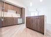 Thumbnail 7 of 22 - A kitchen with wooden cabinets and a white wall.