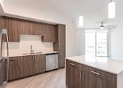 Thumbnail 4 of 22 - A kitchen with brown cabinets and a white counter.