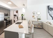 Thumbnail 3 of 26 - A modern kitchen with a white island and stainless steel appliances.