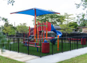 Thumbnail 34 of 36 - a playground is shown behind a black wrought iron fence