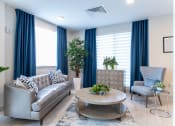 Thumbnail 30 of 41 - a living room with blue curtains and a couch and a table
