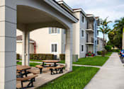 Thumbnail 7 of 23 - A row of apartment buildings with a covered picnic area in front.