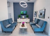 Thumbnail 28 of 36 - a living room with blue couches and a tv