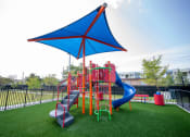Thumbnail 21 of 36 - a playground with a blue umbrella and colorful playset