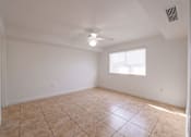 Thumbnail 9 of 23 - A room with a ceiling fan and a window with blinds.