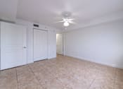 Thumbnail 8 of 23 - A room with a ceiling fan and tile flooring.