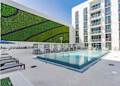 Thumbnail 13 of 26 - a large pool in front of a building with a green wall