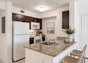 Thumbnail 10 of 33 - A kitchen with granite countertops and stainless steel appliances.