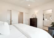 Thumbnail 10 of 16 - a white bedroom with a large bed and a closet