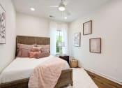 Thumbnail 12 of 16 - a bedroom with a bed and a ceiling fan