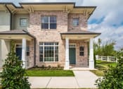 Thumbnail 2 of 16 - the front of a brick townhome with a sidewalk in front of it