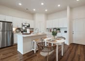 Thumbnail 7 of 16 - an open kitchen and dining area with a table and chairs
