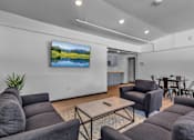 Thumbnail 12 of 12 - A living room with a large screen TV mounted on the wall.