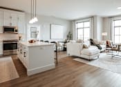 Thumbnail 7 of 52 - A modern kitchen with white appliances and a dining area with a white sofa and chairs.