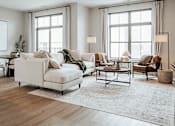 Thumbnail 6 of 52 - A living room with a white sofa and a rug.