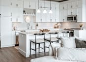 Thumbnail 9 of 52 - A modern kitchen with a large island and stools.