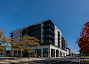 Thumbnail 52 of 52 - A modern multi-story building with a black and white exterior.