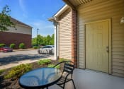 Thumbnail 10 of 26 - a patio with a table and chairs and a yellow door