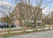 Thumbnail 2 of 34 - A large brick building with a tree in front of it at Shipyard Shores Apartments, Apartments, Newport News, VA