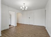 Thumbnail 4 of 34 - A room with a chandelier and wooden floors. at Shipyard Shores Apartments, Newport News, Virginia