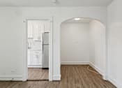 Thumbnail 16 of 34 - A kitchen with white cabinets and a refrigerator is visible through an open doorway at Shipyard Shores Apartments, Apartments, Newport News, VA
