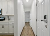 Thumbnail 22 of 34 - A long white hallway with a white door on the right at Shipyard Shores Apartments, Newport News, VA, 23607