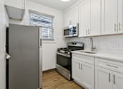 Thumbnail 23 of 34 - A kitchen with a refrigerator, stove, oven, and microwave at Shipyard Shores Apartments, Apartments, Newport News, VA