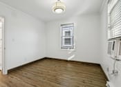 Thumbnail 26 of 34 - A room with wooden floors and a window with blinds at Shipyard Shores Apartments, Newport News