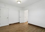 Thumbnail 27 of 34 - A room with two white doors and a wooden floor at Shipyard Shores Apartments, Virginia