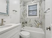 Thumbnail 28 of 34 - A white bathroom with a marble tile wall at Shipyard Shores Apartments, Virginia, 23607