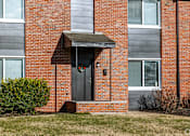 Thumbnail 2 of 20 - A red brick building with a black door and a small porch. at Blacklark Apartments, Apartments, Kansas City, KS