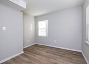 Thumbnail 17 of 20 - A room with wooden flooring and a window with blinds. at Blacklark Apartments, Kansas City, 66101