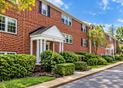 Thumbnail 5 of 10 - A red brick building with a white door and windows.