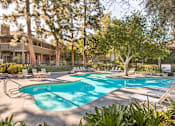 Thumbnail 9 of 19 - A large outdoor swimming pool surrounded by trees and lounge chairs at The Aspens Riverside, Riverside, 92504
