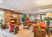 Thumbnail 15 of 23 - A clubhouse living room with a fireplace and a couch at The Aspens Fairhaven, Santa Ana, 92705